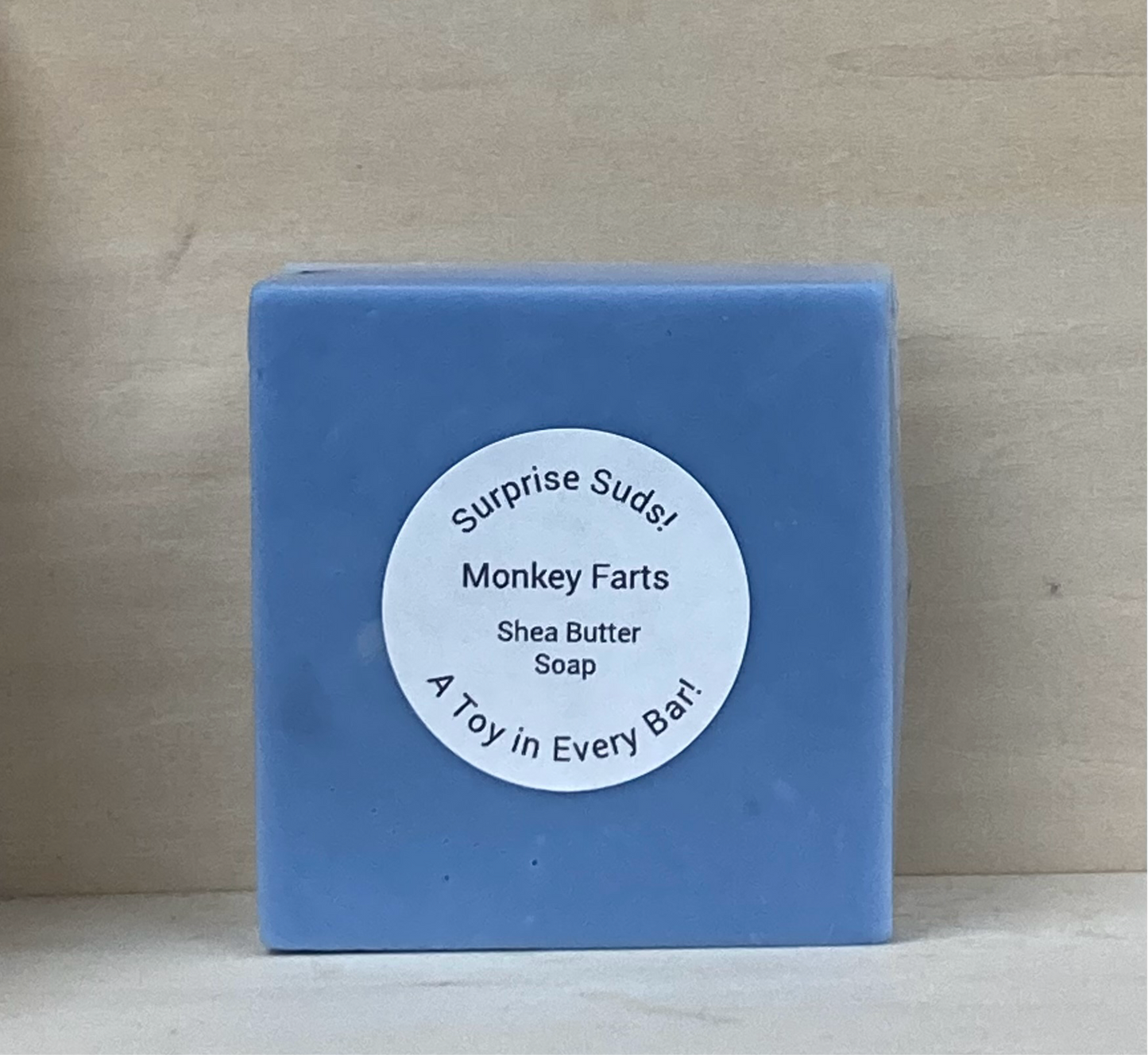 Surprise Suds – Monkey Farts Scented Shea Butter Soap
Price: $8
Turn bath time into a thrilling adventure with Surprise Suds! These vibrant blue bars aren’t just soap—they’re a treasure trove of fun, hiding a special toy inside for extra bathtime excitement!
Infused with skin-nourishing shea butter, this soap creates a rich, moisturizing lather while the playful Monkey Farts scent fills the air with a fruity blend of bananas, berries, and a hint of vanilla. As your little one scrubs away, the excitement b