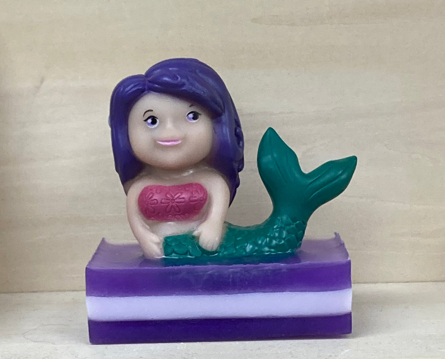 Make bath time magical with our Lydia the Mermaid Bath Buddy! A whimsical mermaid toy with vibrant purple hair perches gracefully atop a handcrafted bar of soothing shea butter and glycerin soap.  Each Bath Buddy comes with its own story.  Infused with a calming lavender scent, this delightful bath accessory is perfect for little mermaids, princesses, or anyone who loves a splash of fun and relaxation.