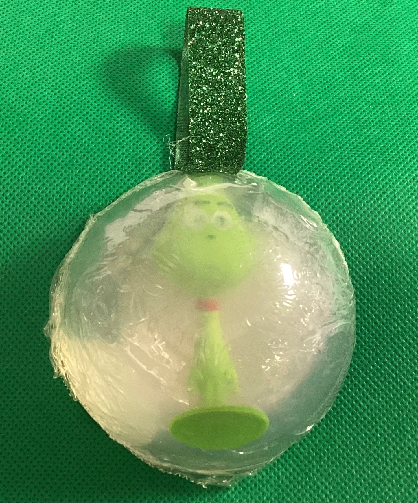   Grinch toy in a bar of Peppermint scent glycerin soap