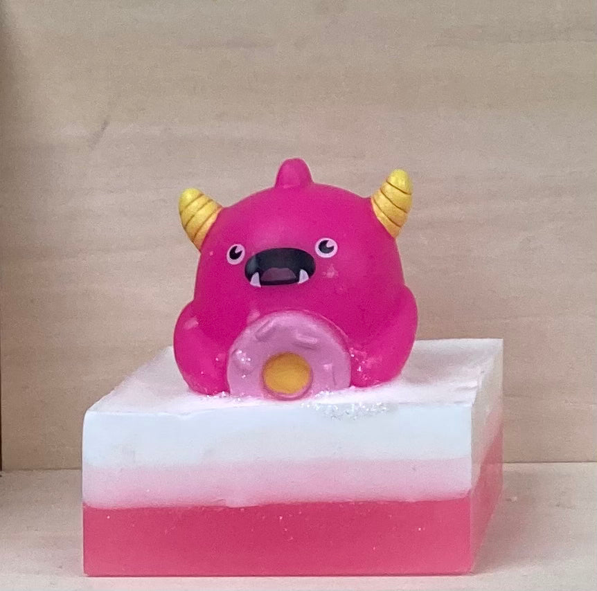 Make bath time a sweet adventure with Pogo, your pink, donut-loving Bath Buddy!

Pogo is ready to sprinkle some fun into your tub and turn bath time into a donut-filled delight! With a delicious bubble gum scent, Pogo sits atop a handcrafted bar of nourishing shea butter and glycerin soap, bringing a sugary fragrance and sensory joy to every bath.

Features:

Handcrafted shea butter and glycerin soap
Exciting bubble gum fragrance
Playful donut-loving monster toy
Soft and squishy texture for fun sensory play
