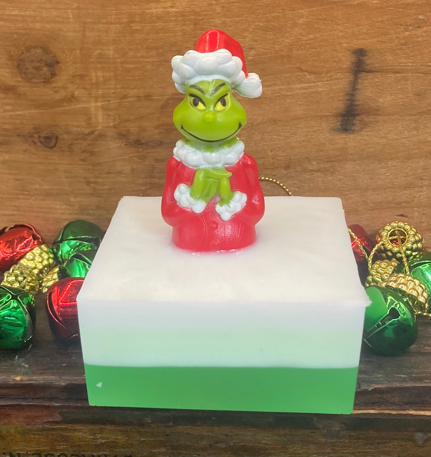 The Grinch sits atop a bar of Winter Berry scented Shea Butter and Glycerin Soap.